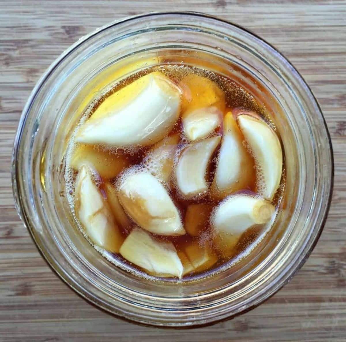 Fermented honey garlic in a glass jar.