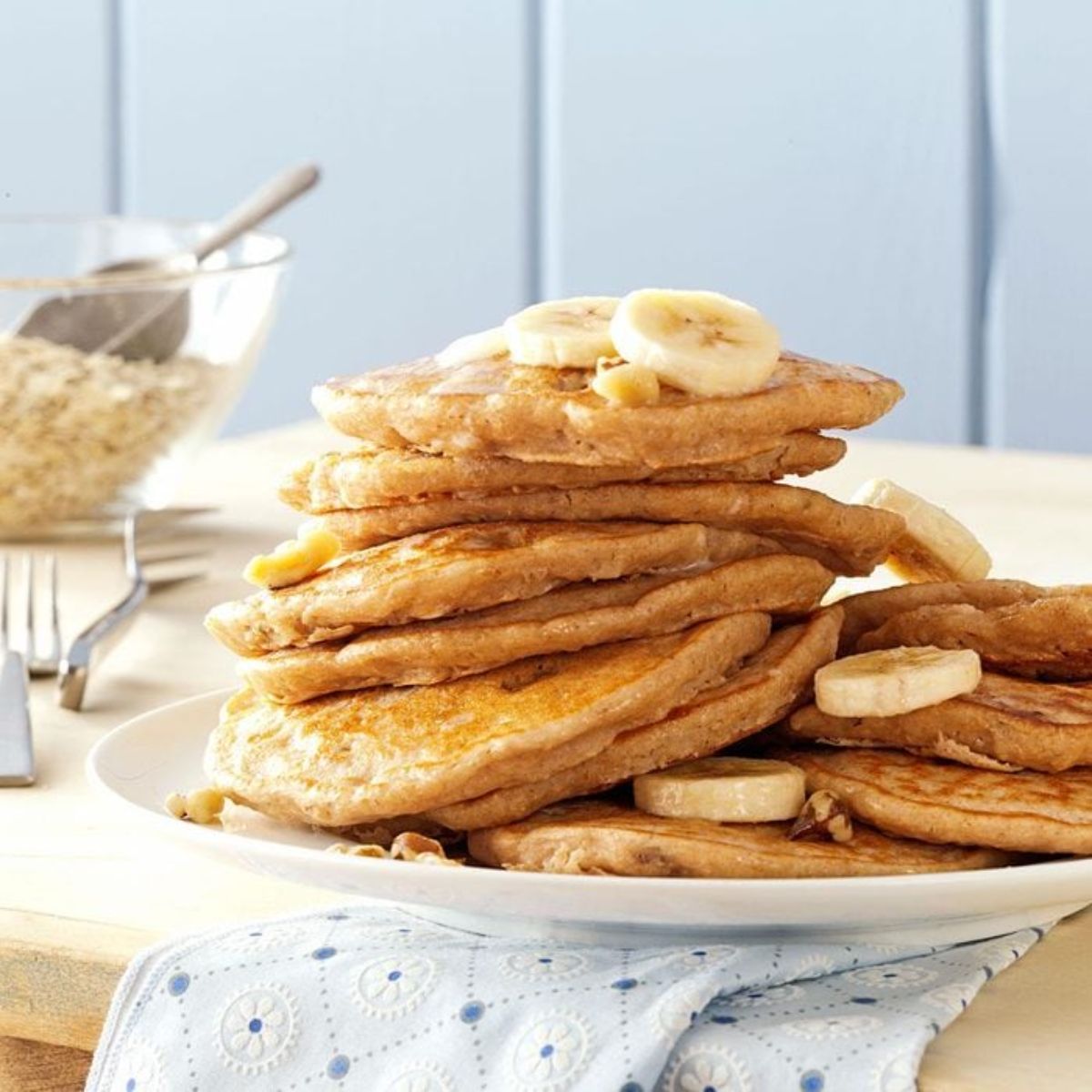 A pile of banana oatmeal pancakes on a white plate.