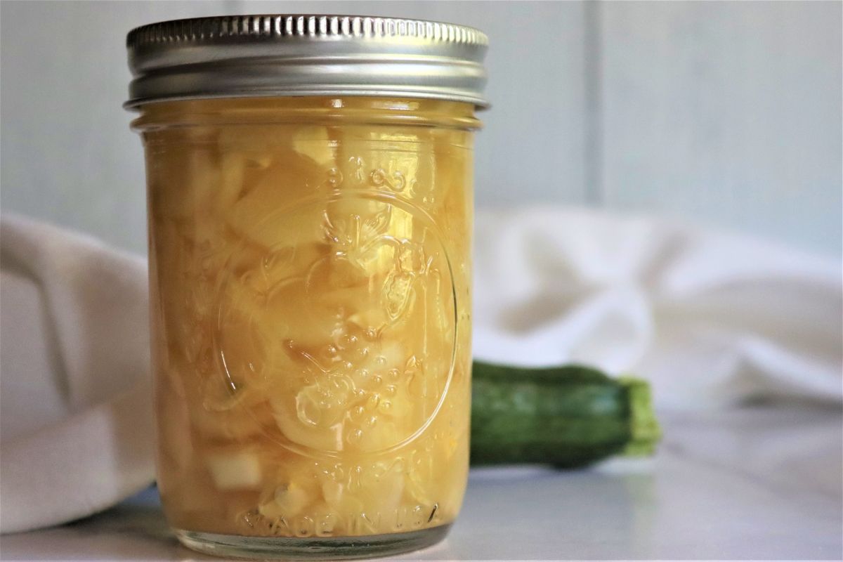 Canning zucchini in pineapple juice in a glass jar.