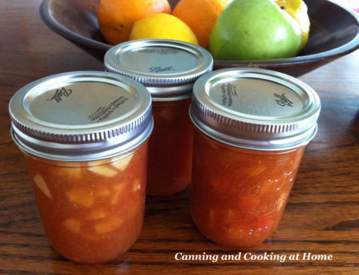 Cherry and granny smith apple preserves in three glass jars.