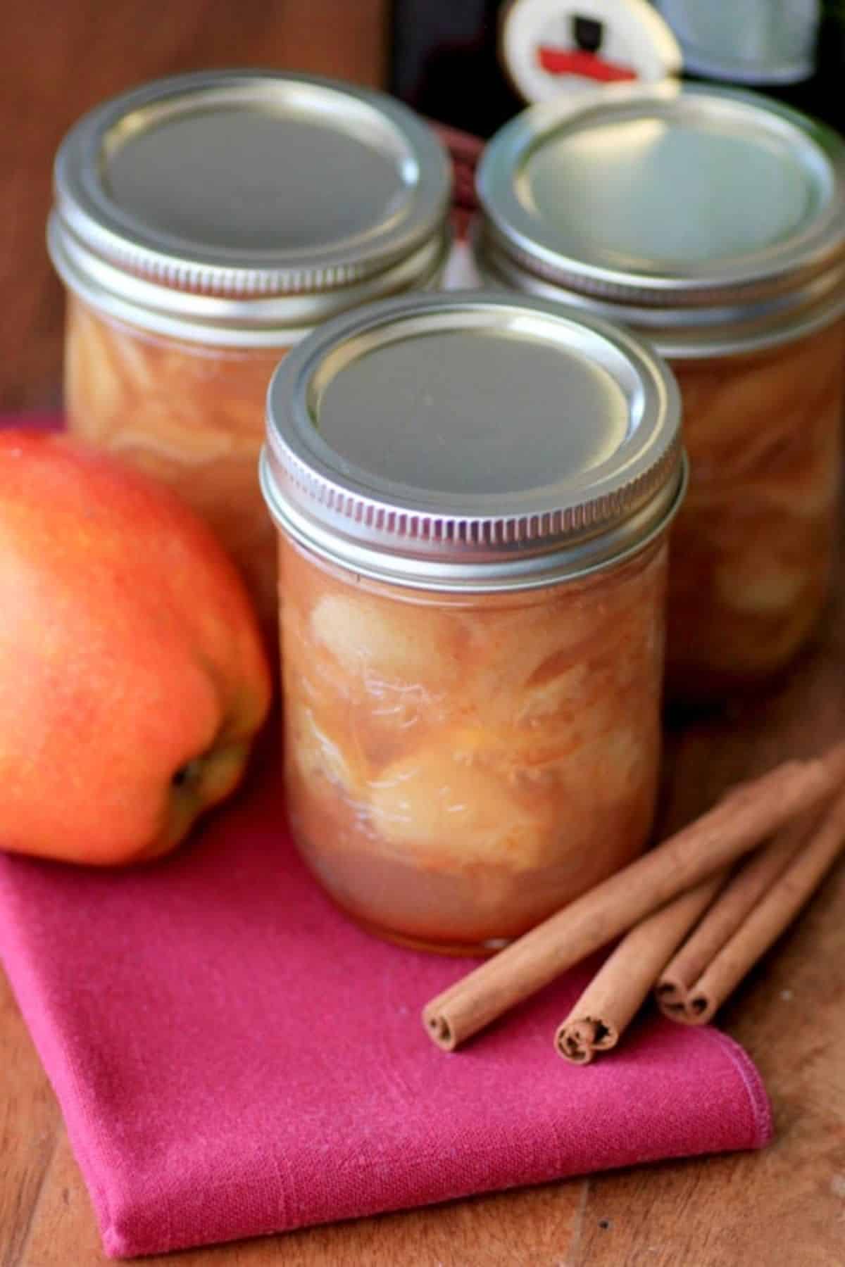 Brandied cinnamon apple preserves canned in three glass jars.