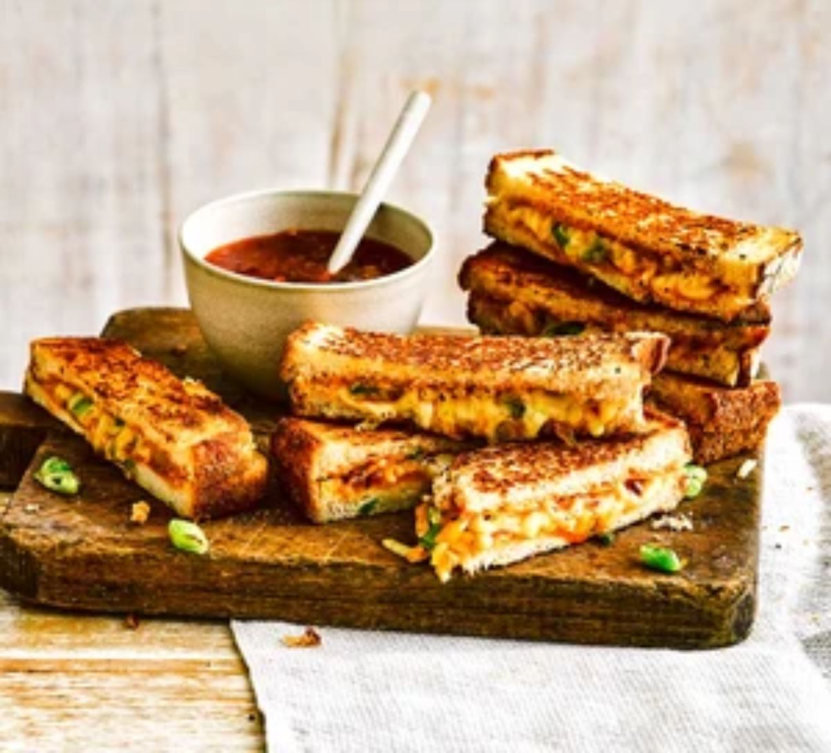 Mango chutney campfire cheese toasties on a wooden cutting board.