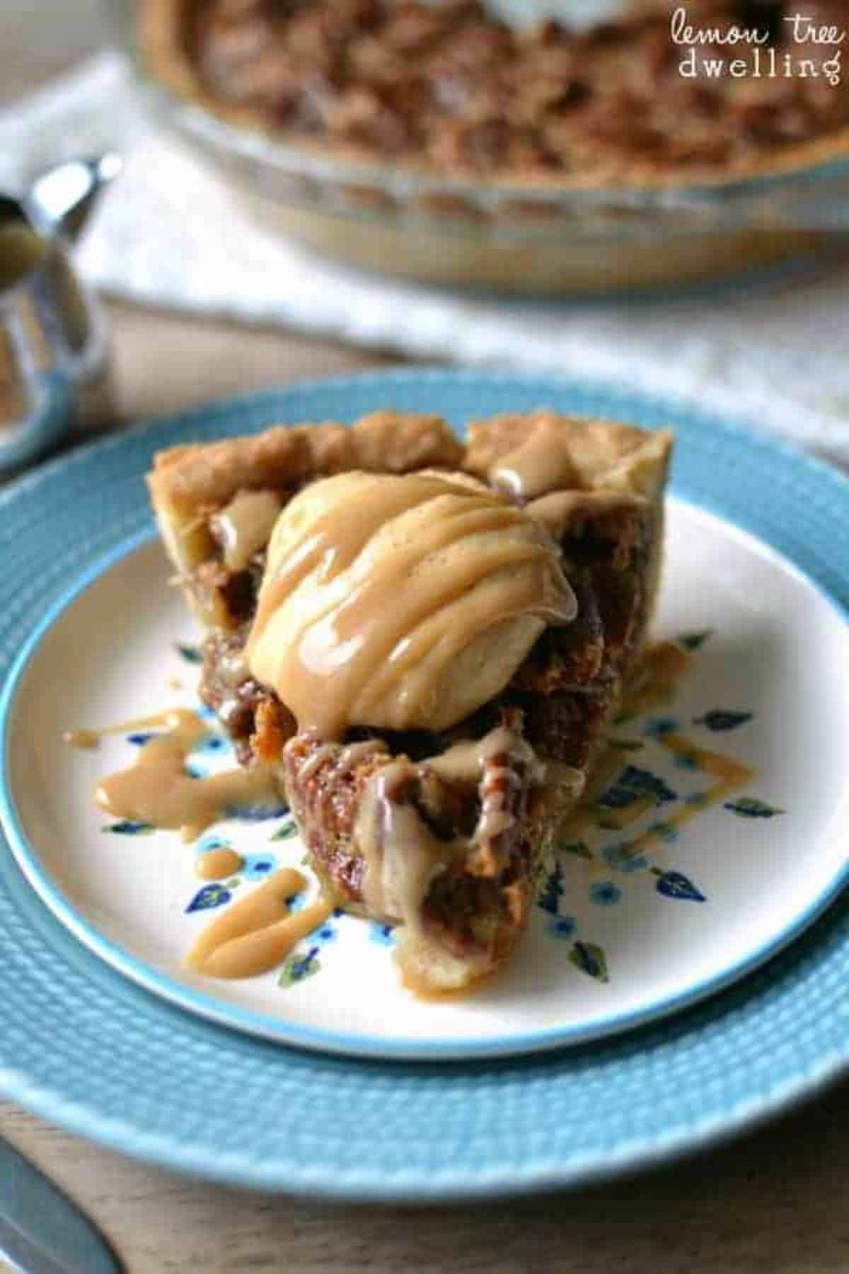 A piece of salted caramel pumpkin pecan pie on a white-blue plate.