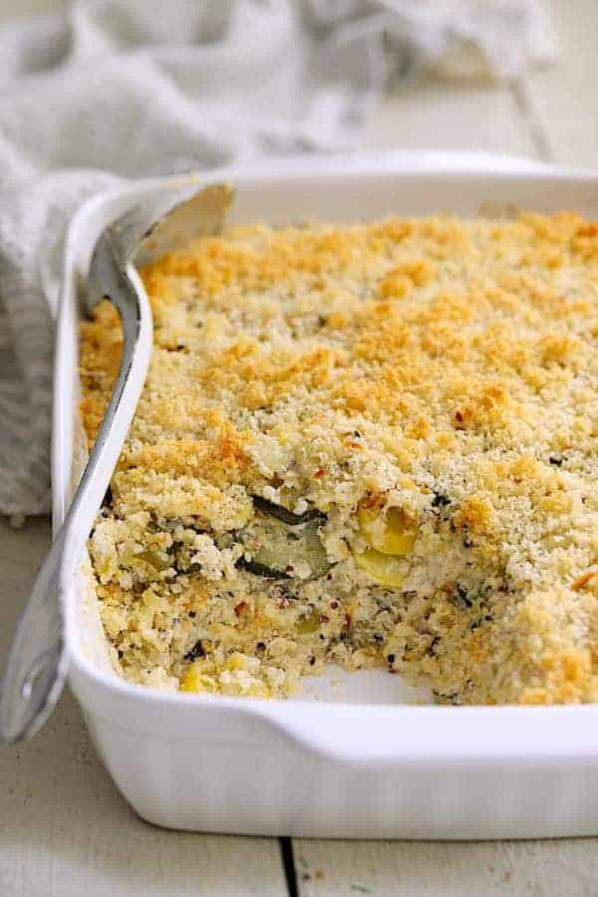 Zucchini, yellow squash, and quinoa in a white casserole.