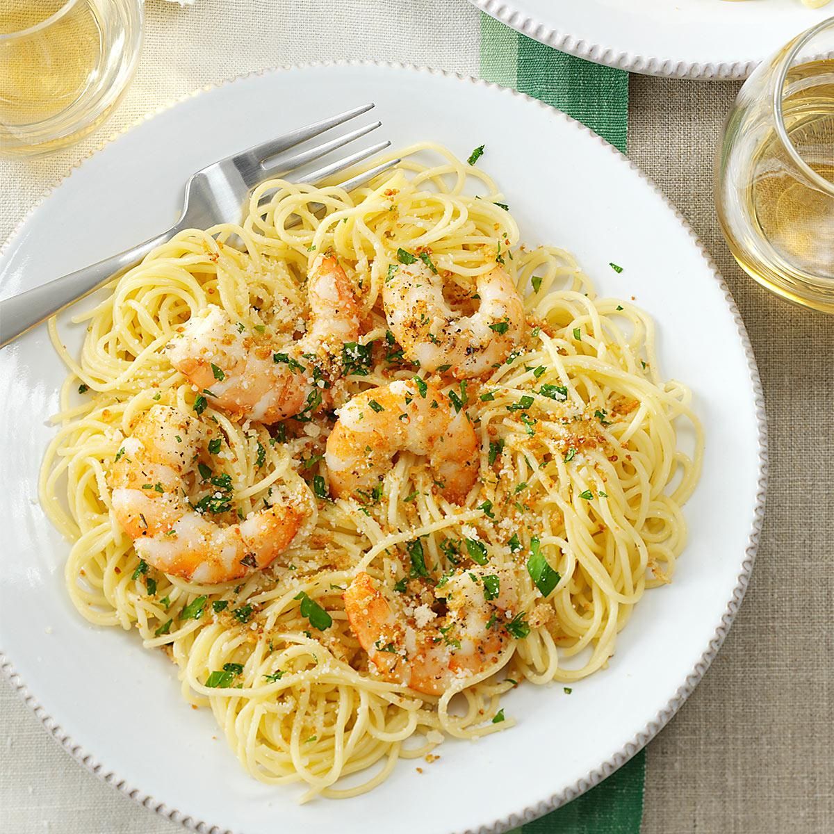 Delicious shrimp scampi pasta with spinach on a white plate with a fork.