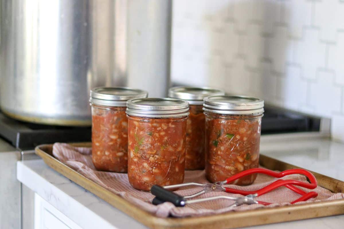 Canned chili con carne in glass jars.