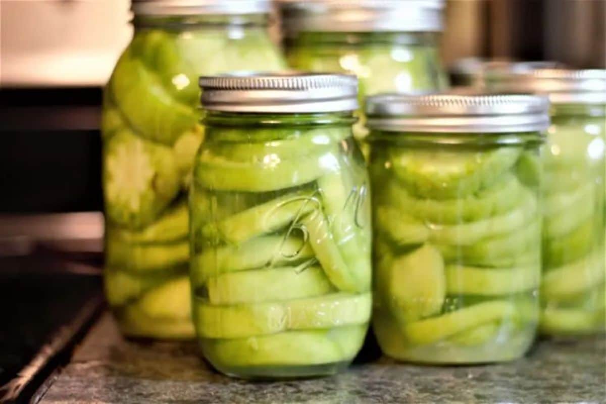 Canning green tomatoes in glass jars.