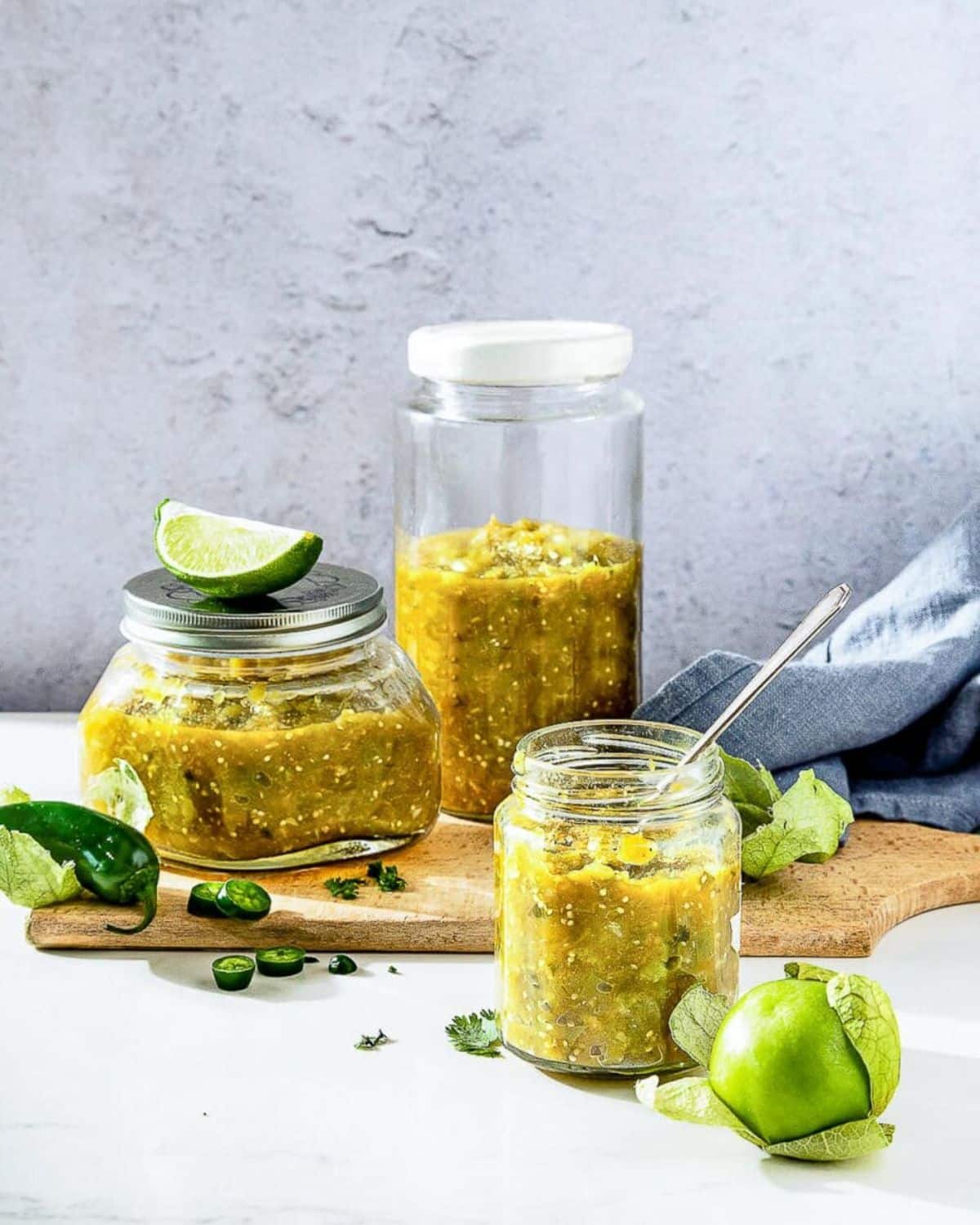 Salsa verde in three glass jars.