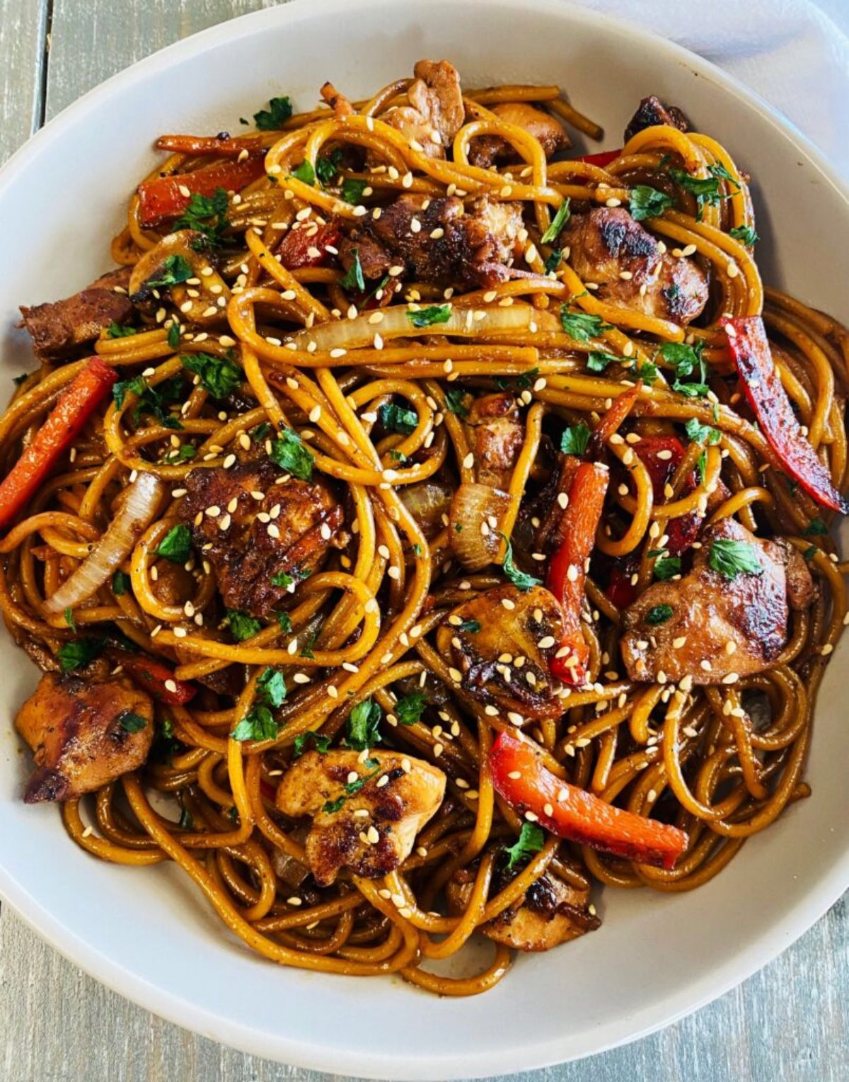 Blackstone chicken lo mein in a white bowl.