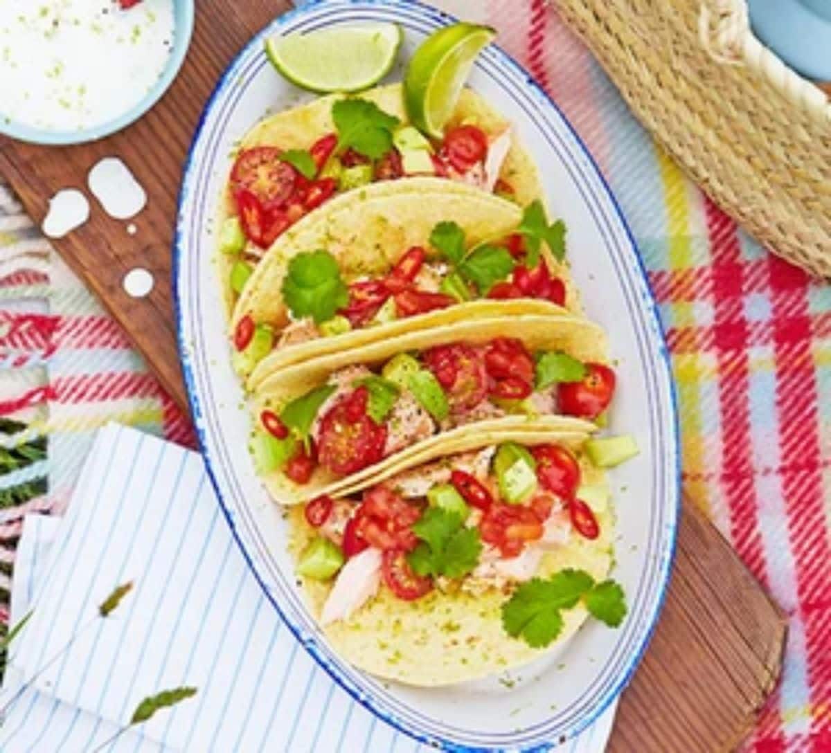 Salmon tacos with lime dressing on a tray.