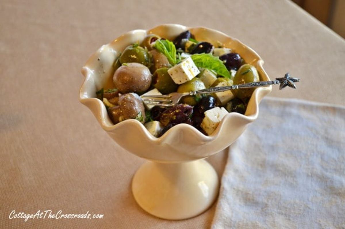 Marinated olives and feta cheese in a fancy bowl.