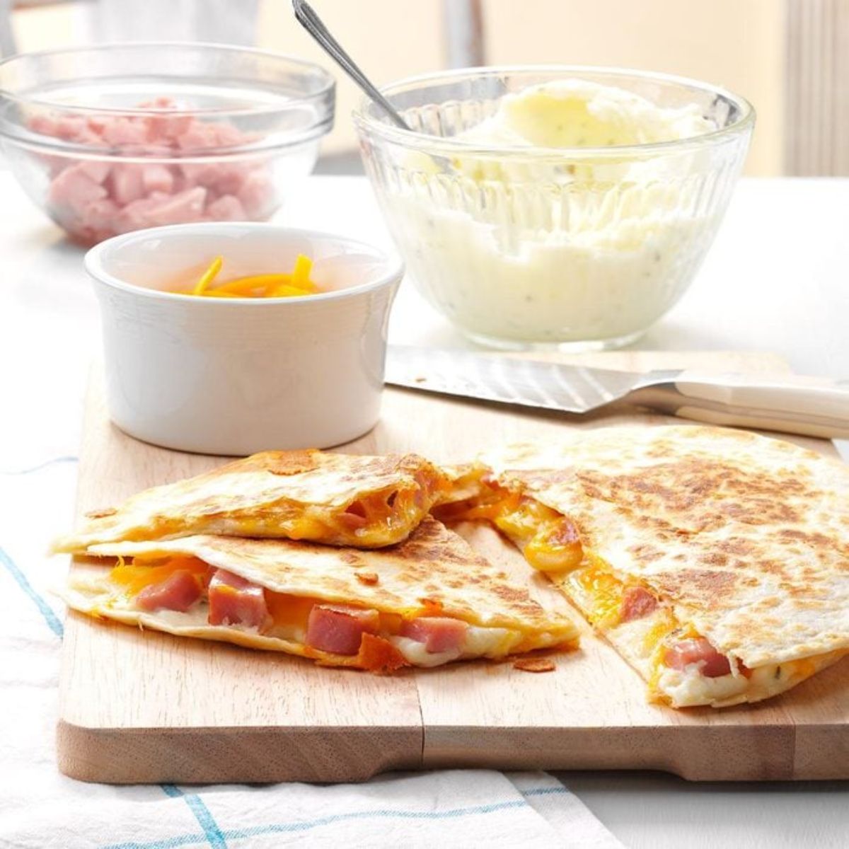 Pierogi quesadillas on a wooden cutting board.