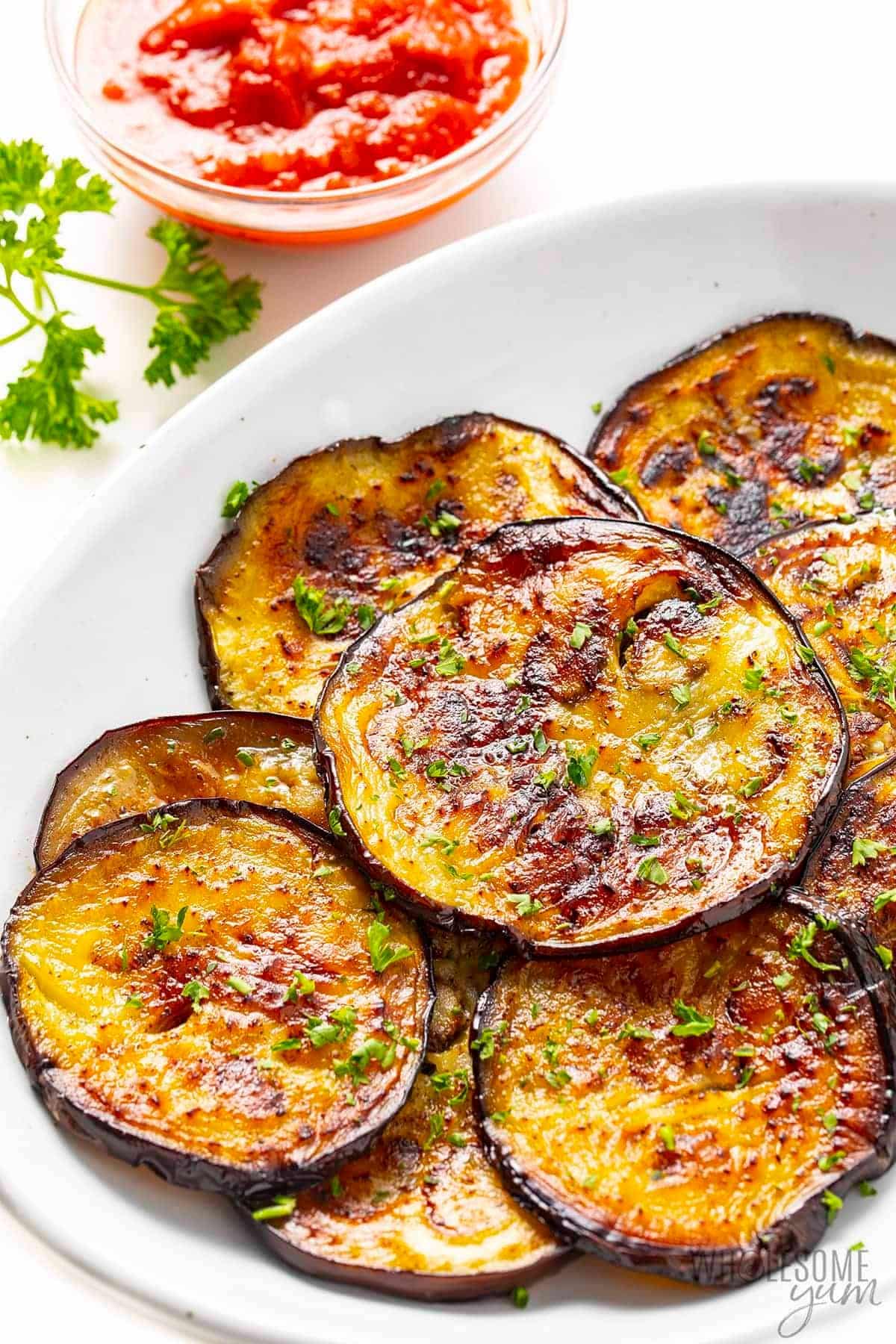 Sauteed eggplant in a white bowl.