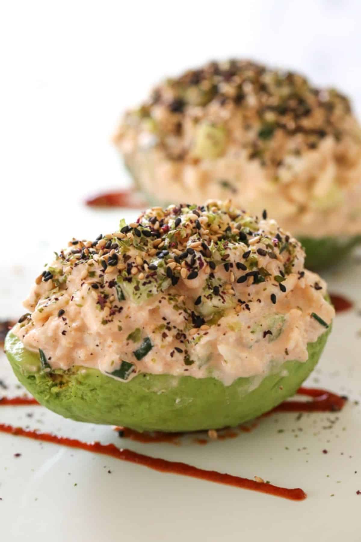 Healthy california spicy crab stuffed avocados on a white tray.