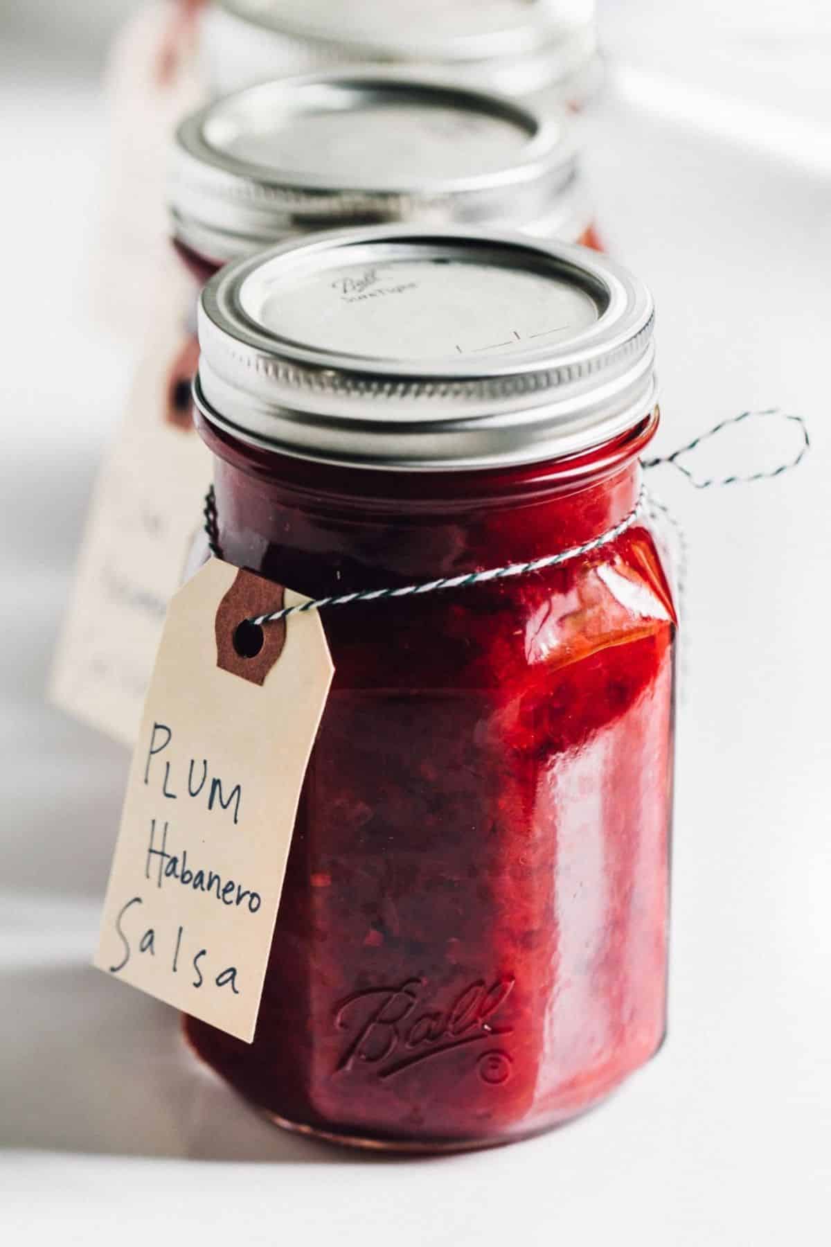 Plum habanero salsa in glass jars.