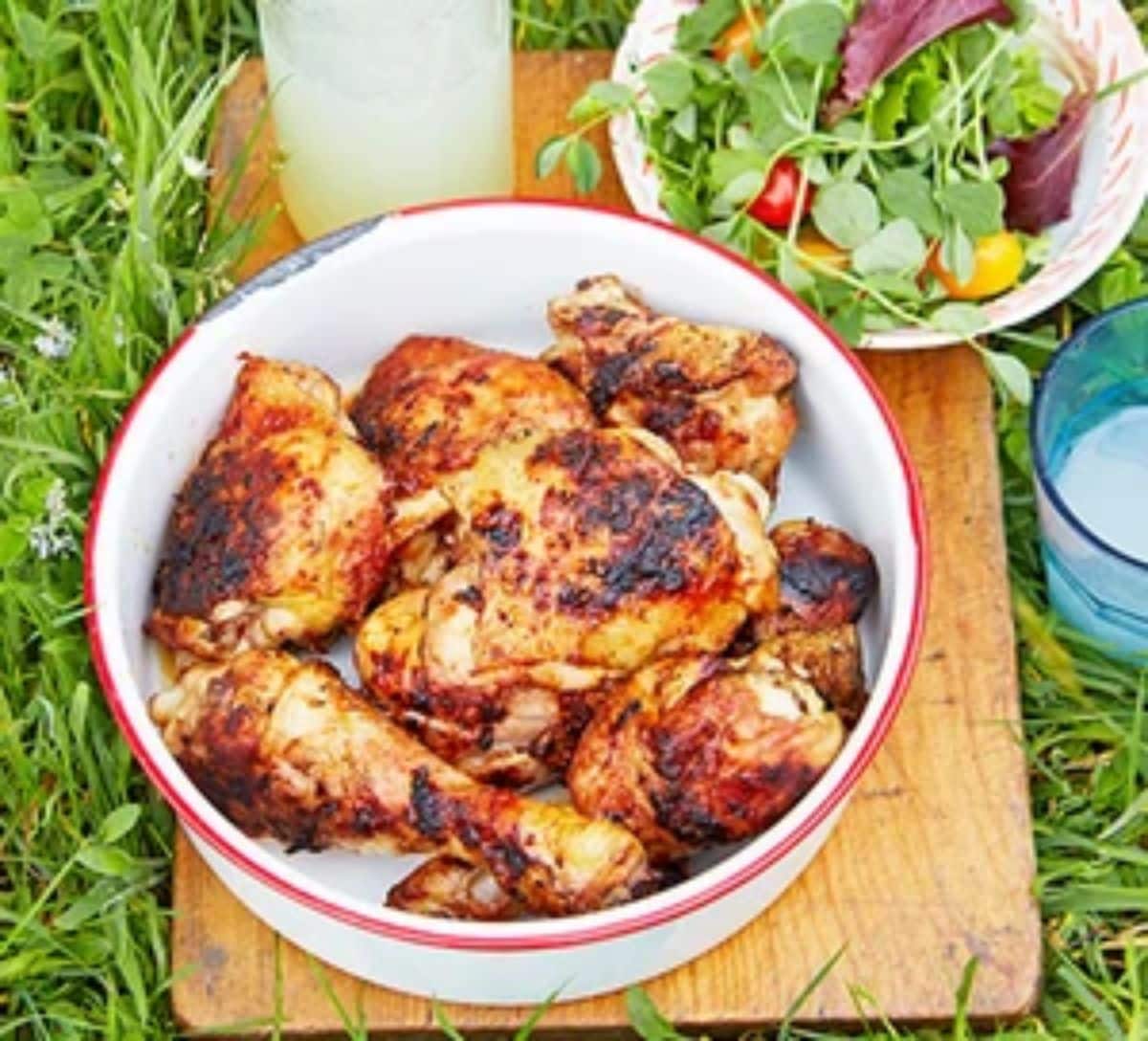 Sticky barbecue chicken in a white-red bowl.