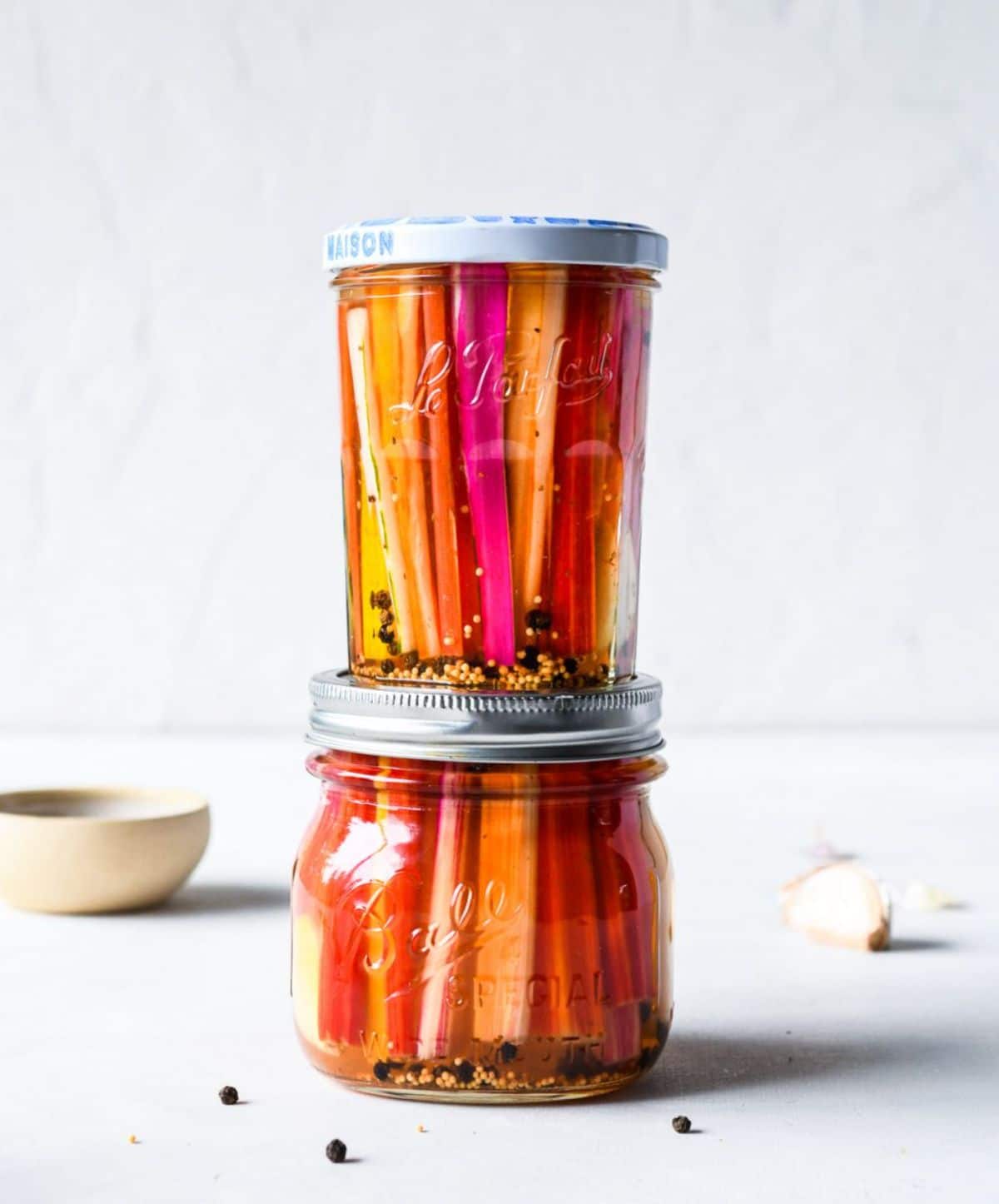 Spicy pickled swiss chard stems in two glass jars.
