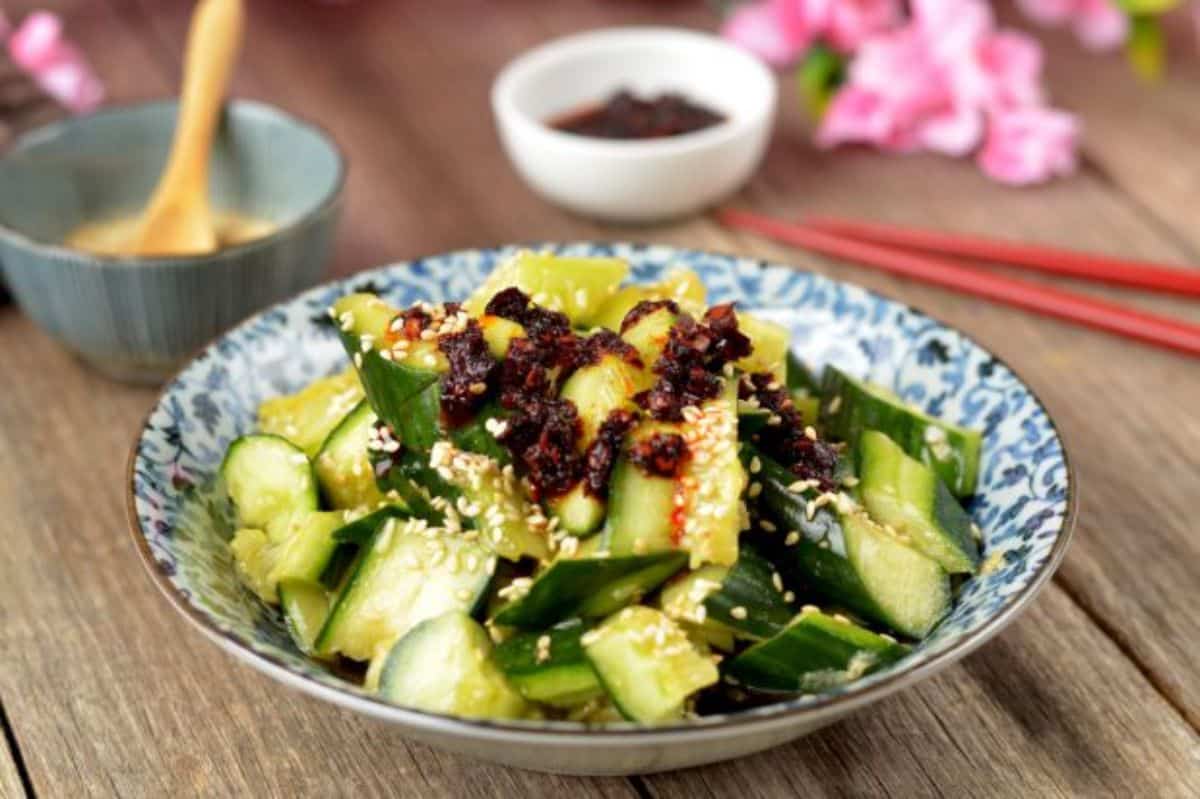 Healthy chinese smashed cucumber salad in a white-blue bowl.