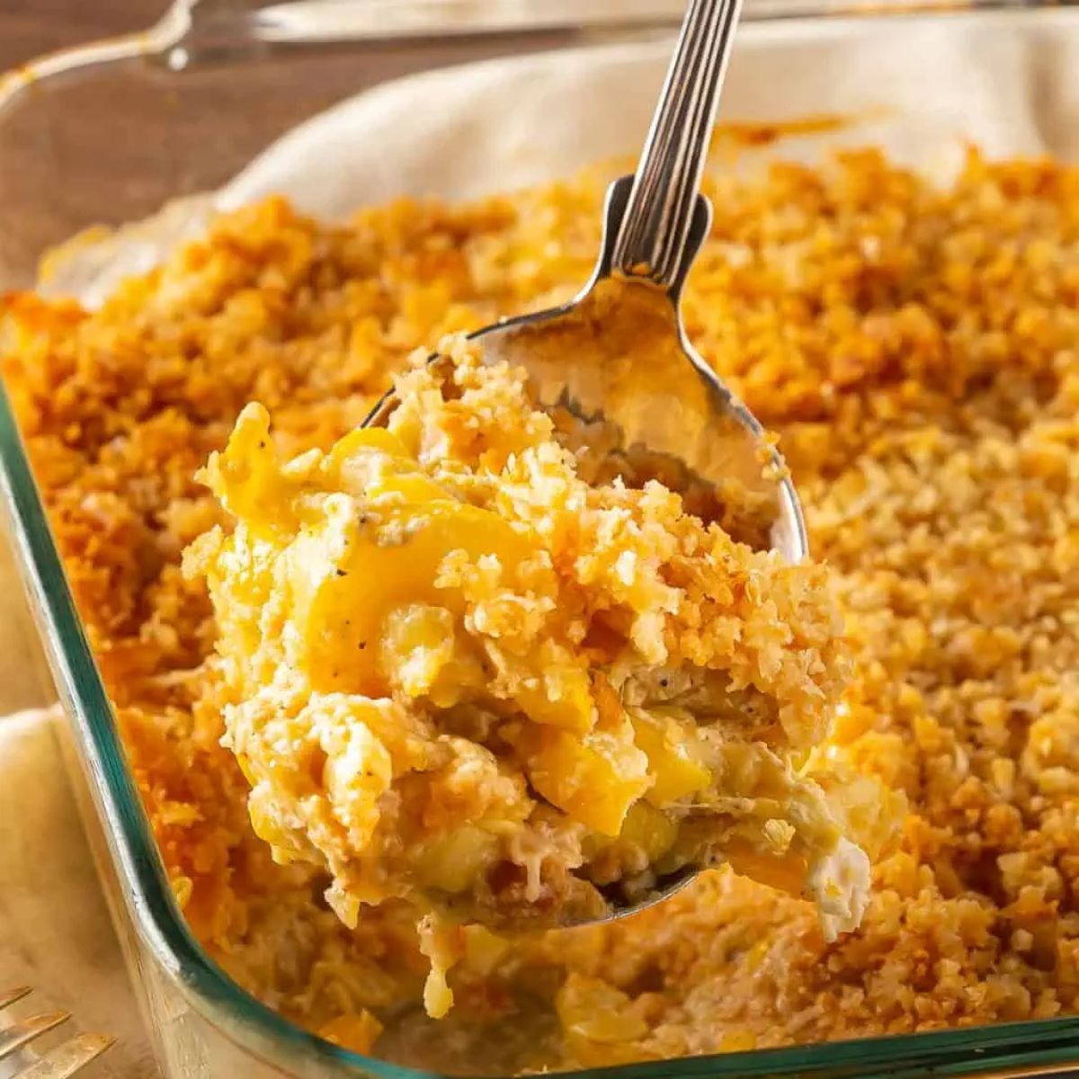 Southern squash in a glass casserole picked with a a spoon.