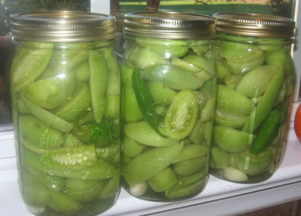 Spiced green tomatoes canned in glass jars.