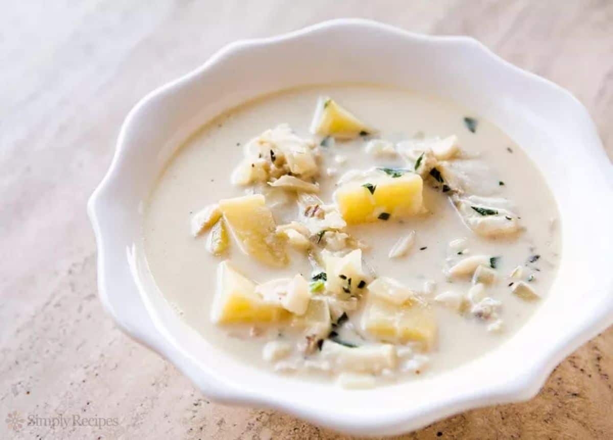 Healthy fish chowder in a white bowl.