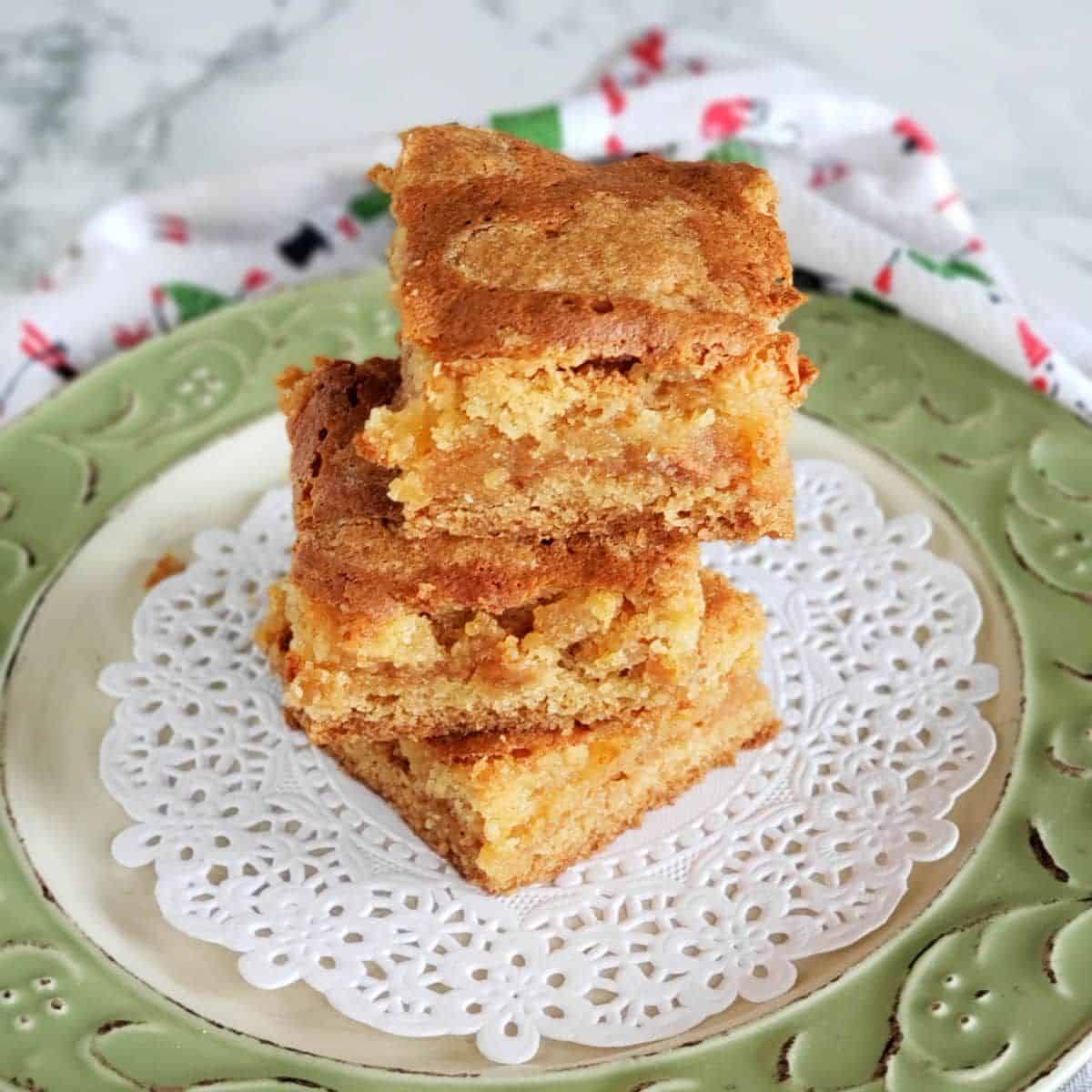 A pile of almond paste squares on a tray.