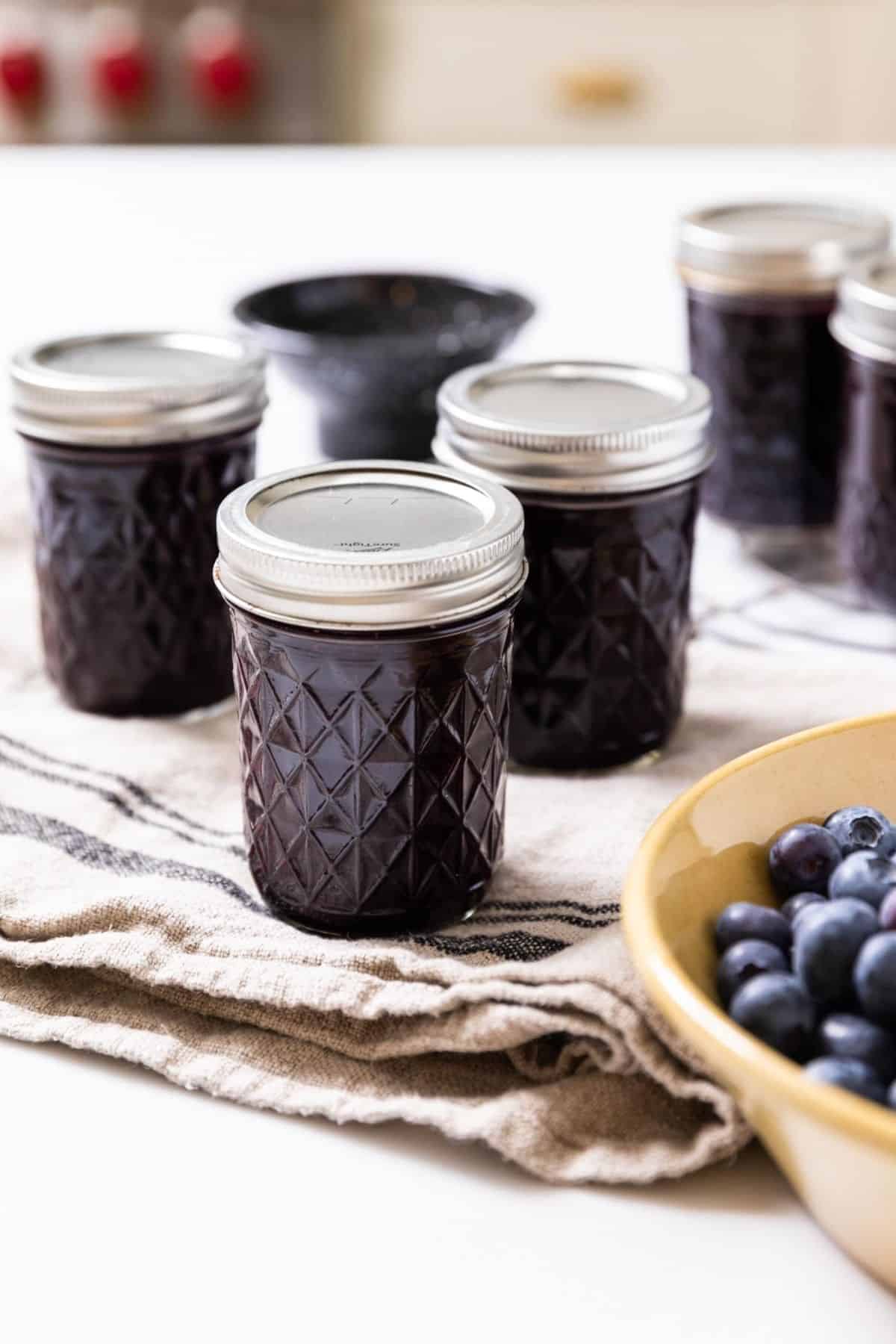 Blueberry jam in glass jars on a table.