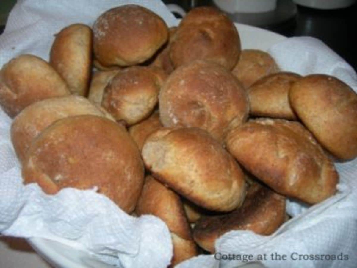 A bunch of whole wheat rolls in a bowl.