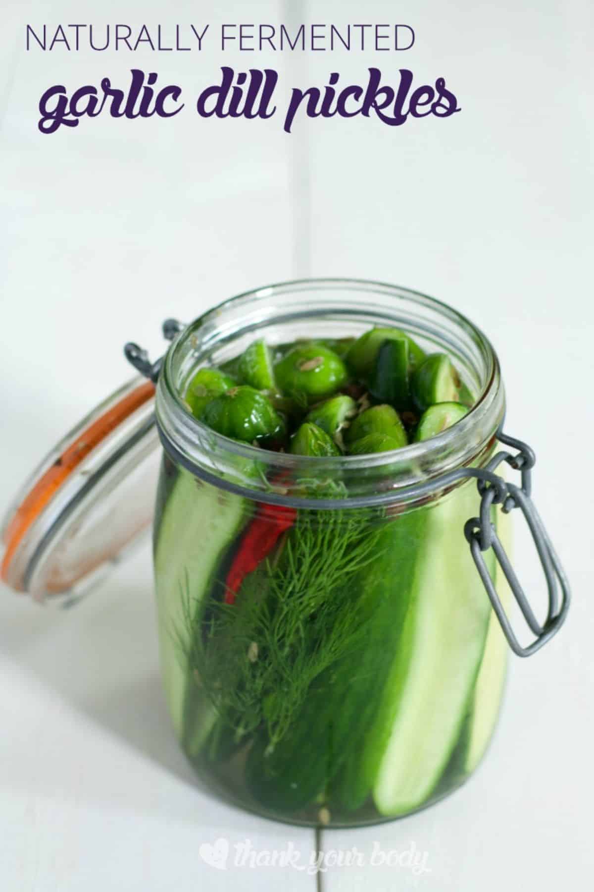 Fermented dill pickles in a glass jar.