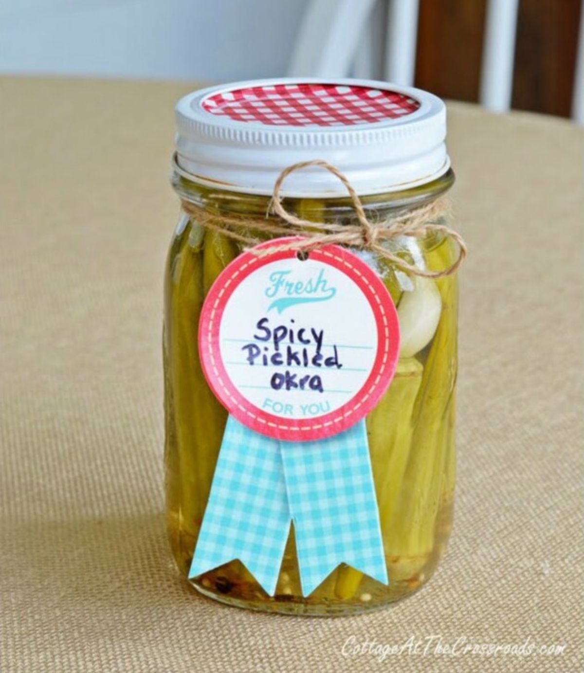Spicy pickled okra in a glass jar.