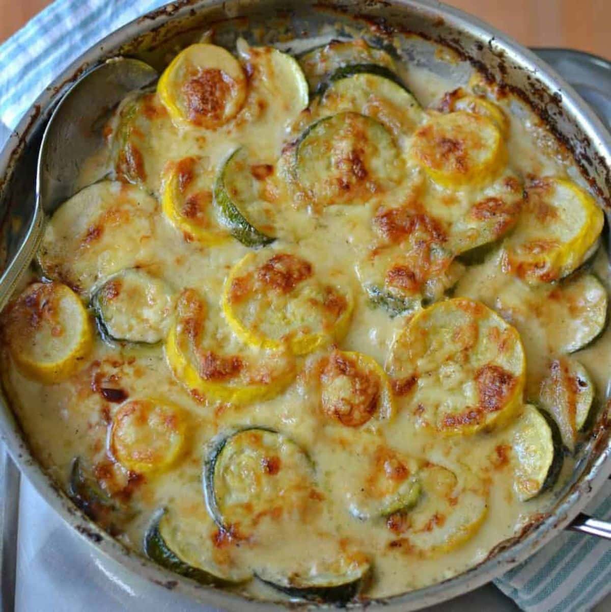 Zucchini gratin with yellow squash in a skillet.