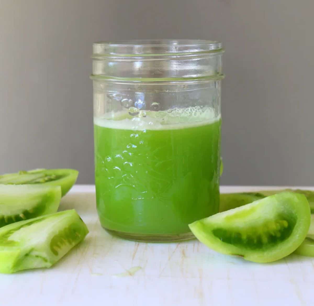 Green tomato juice in a glass jar.