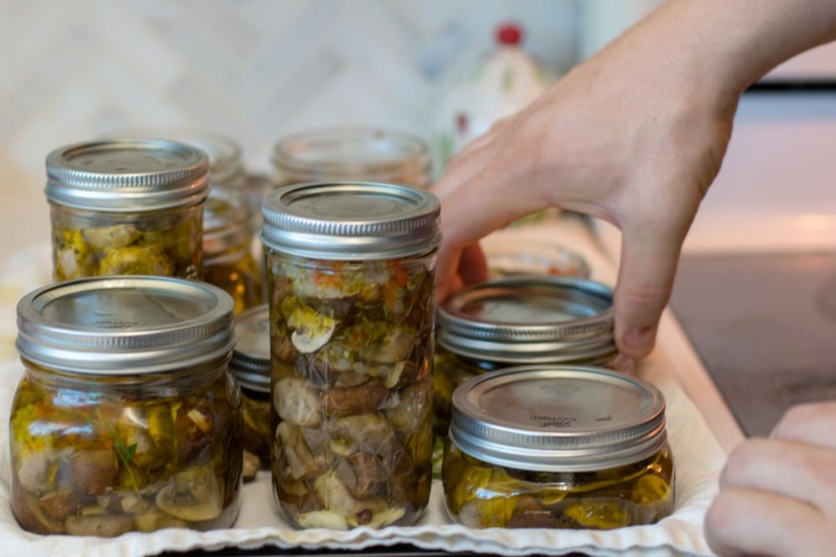 Canned italian marinated mushrooms in glass jars.