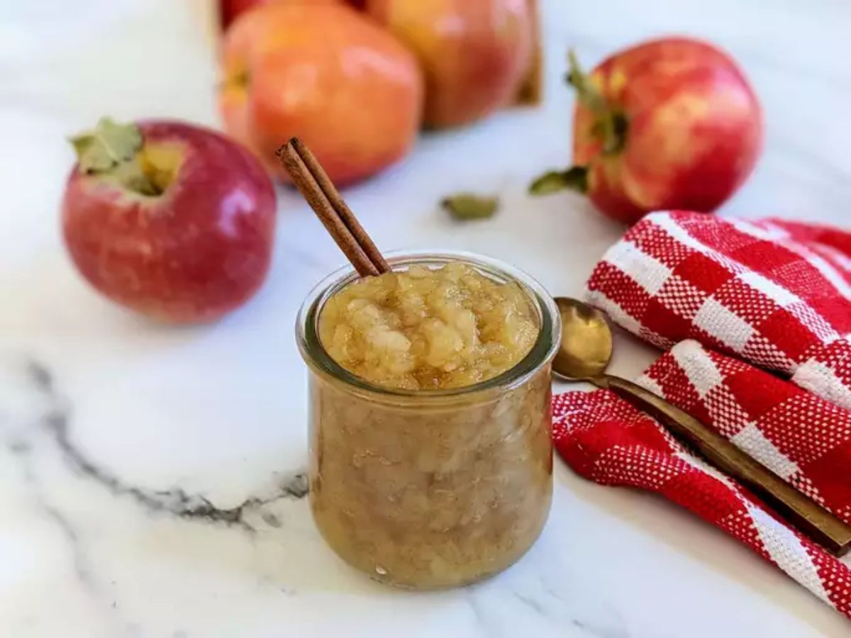 Delicious applesauce in a glass cup with cinnamon stick.