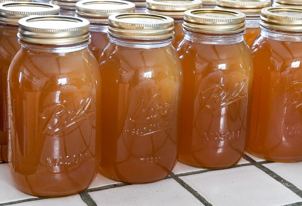 Canned meat stock or broth in glass jars.