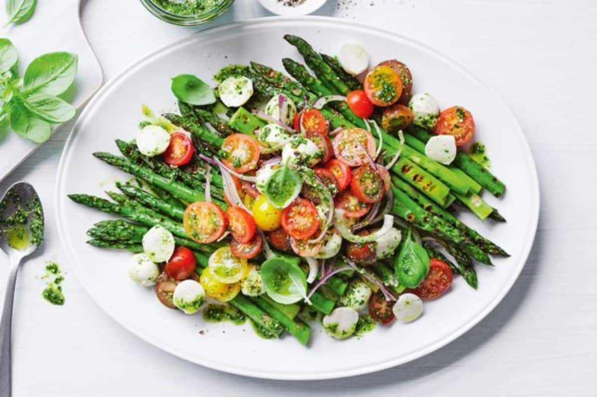 Bbq asparagus caprese salad on a white plate.