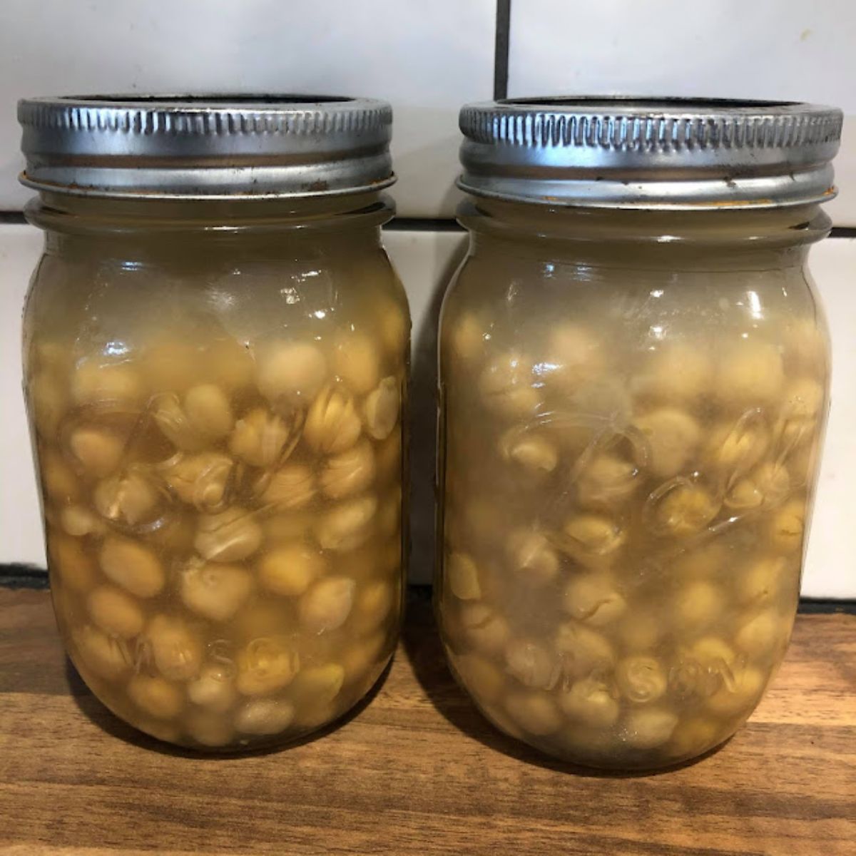 Canned chickpeas in two glass jars.
