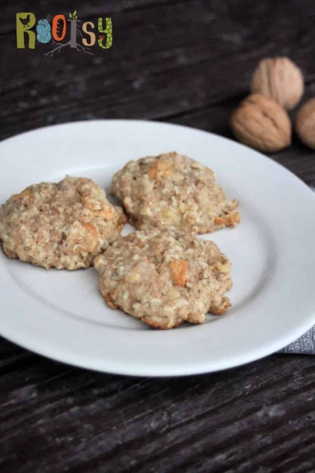 Three maple apple oatmeal cookies on a white plate.