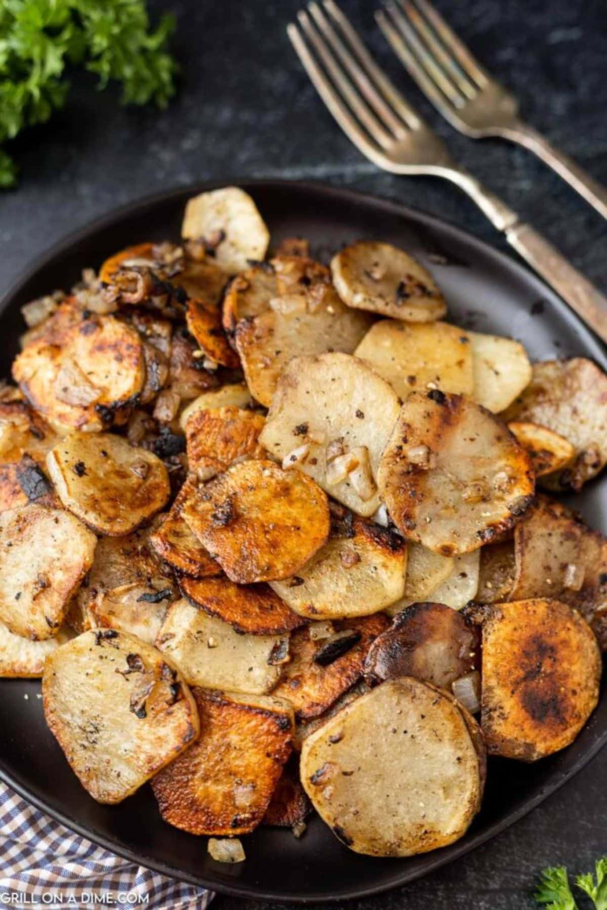 Blackstone fried potatoes on a black skillet.