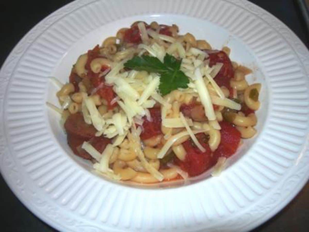 Macaroni and stewed tomatoes on a white plate.
