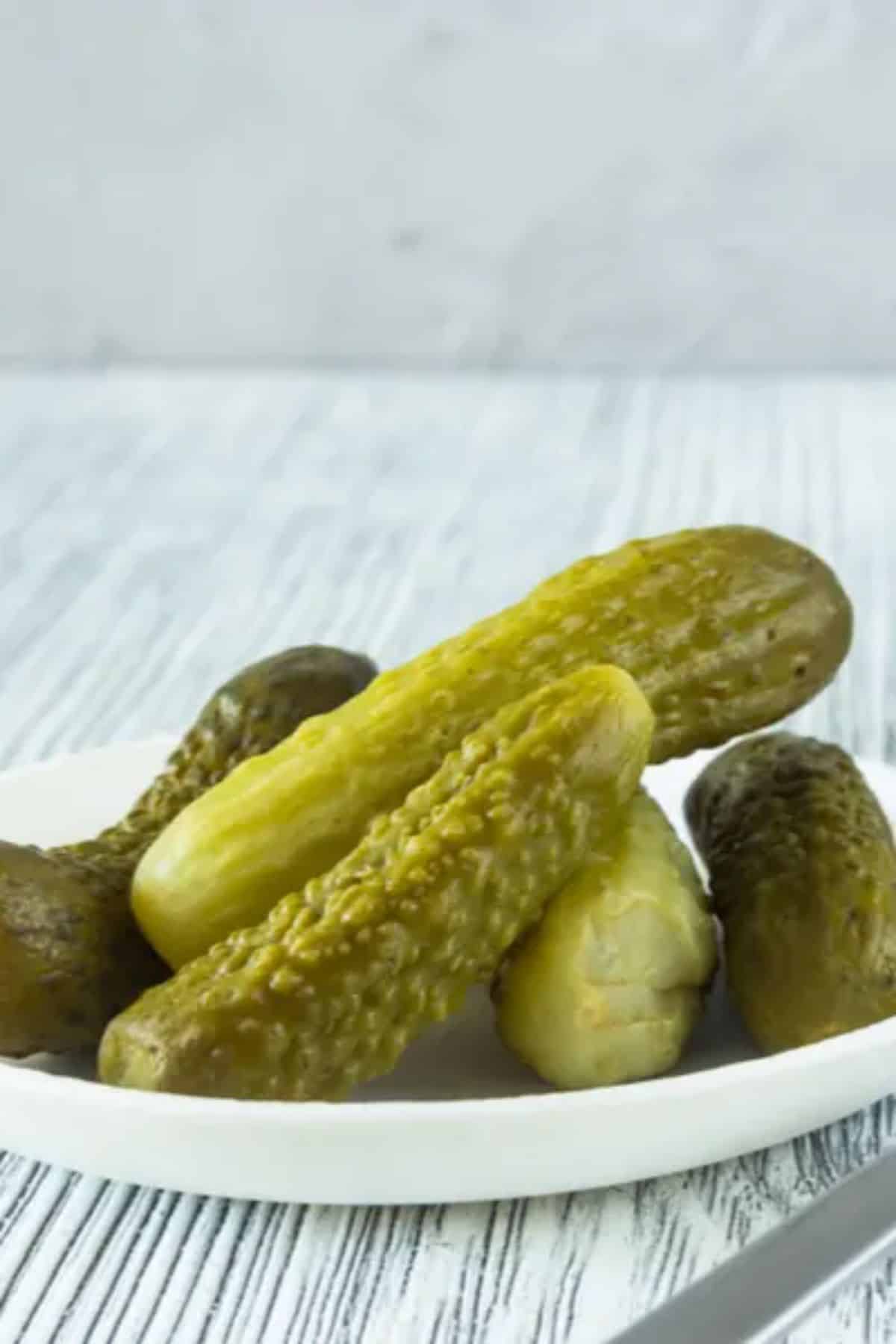 Homemade gherkin pickles on a white plate.