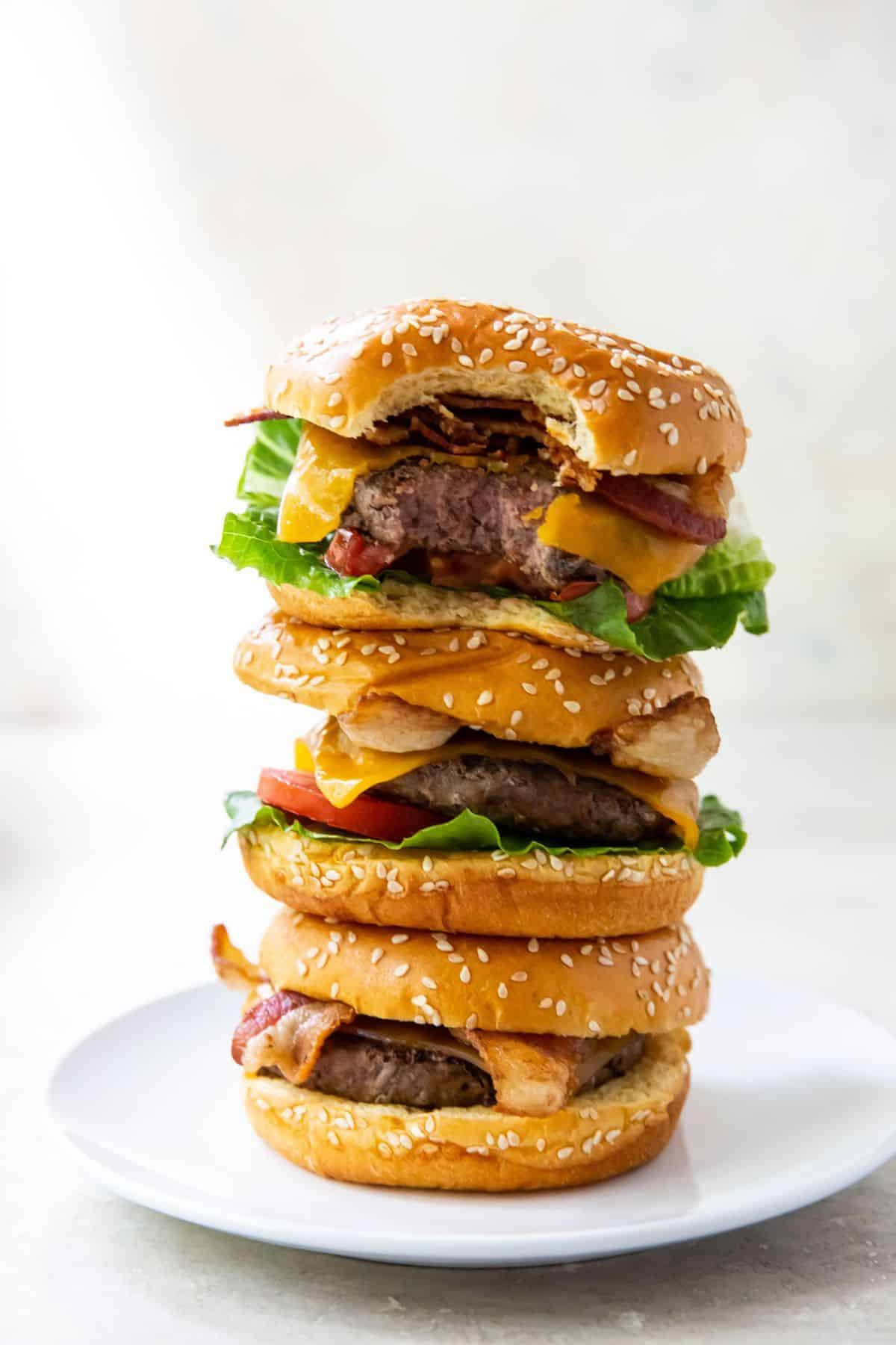 Stack of juicy blackstone burgers on a white plate.