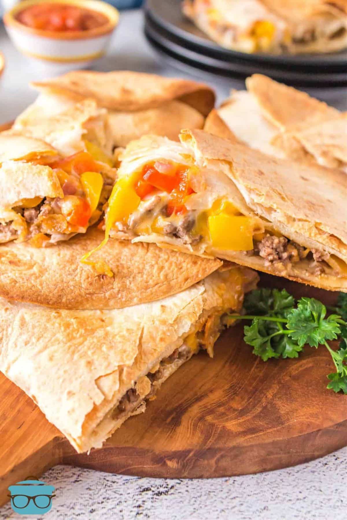 Beef quesadillas on a wooden cutting board.