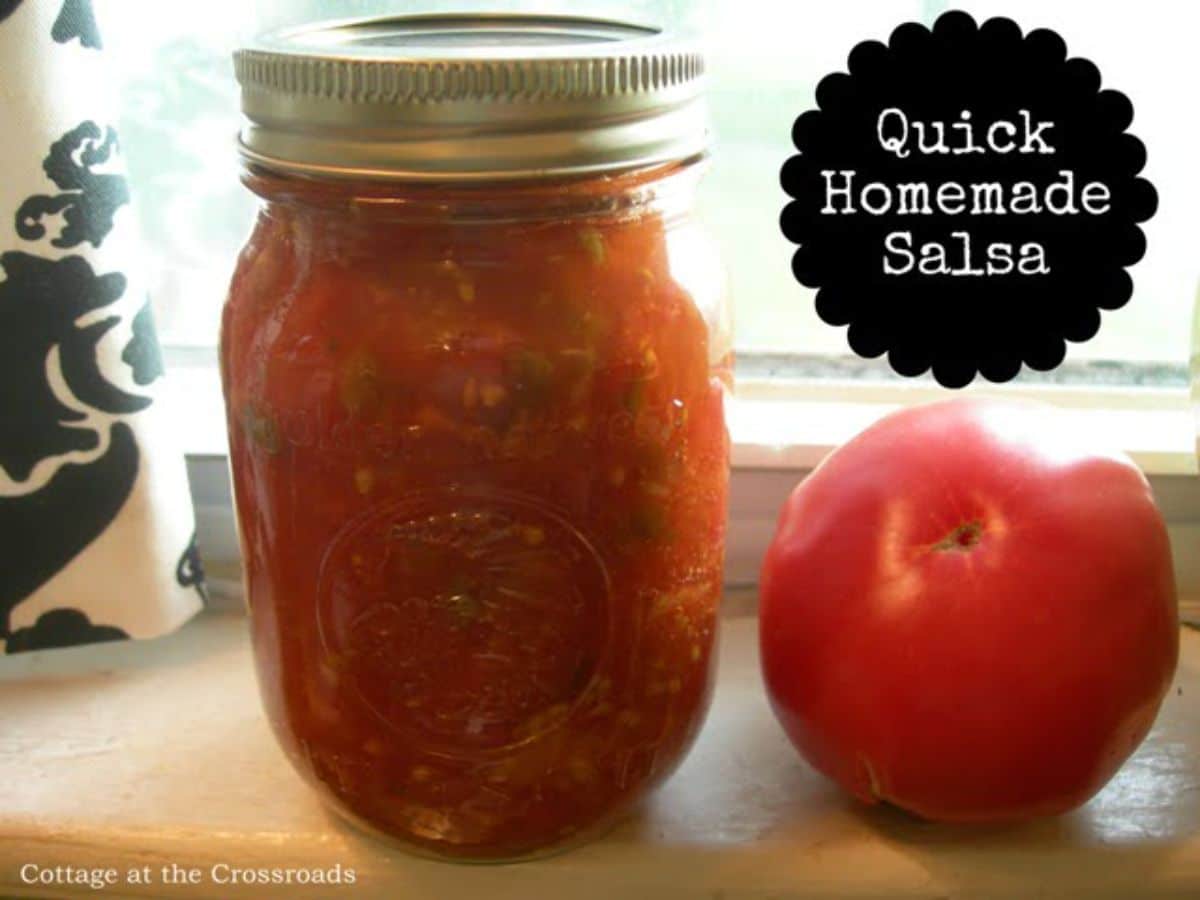 Quick homemade salsa in a glass jar o a windowsill.