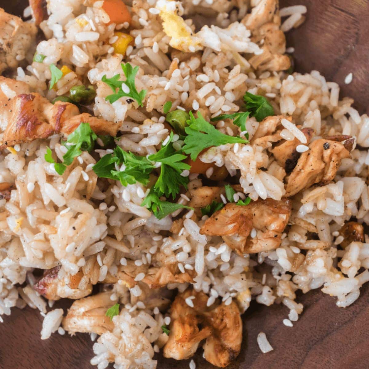 Blackstone fried rice with chicken in a wooden bowl.