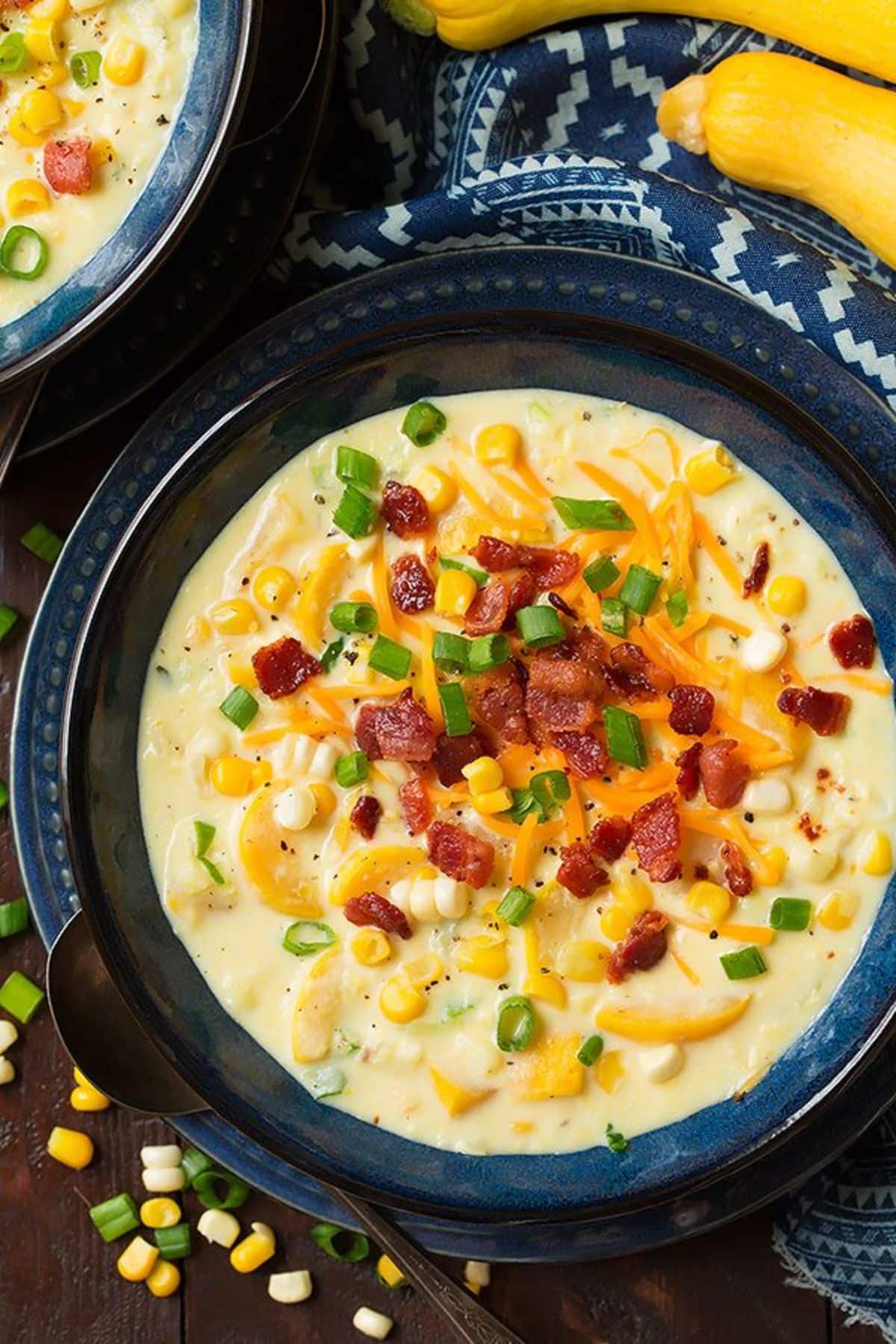 Summer squash and corn chowder on a blue plate.