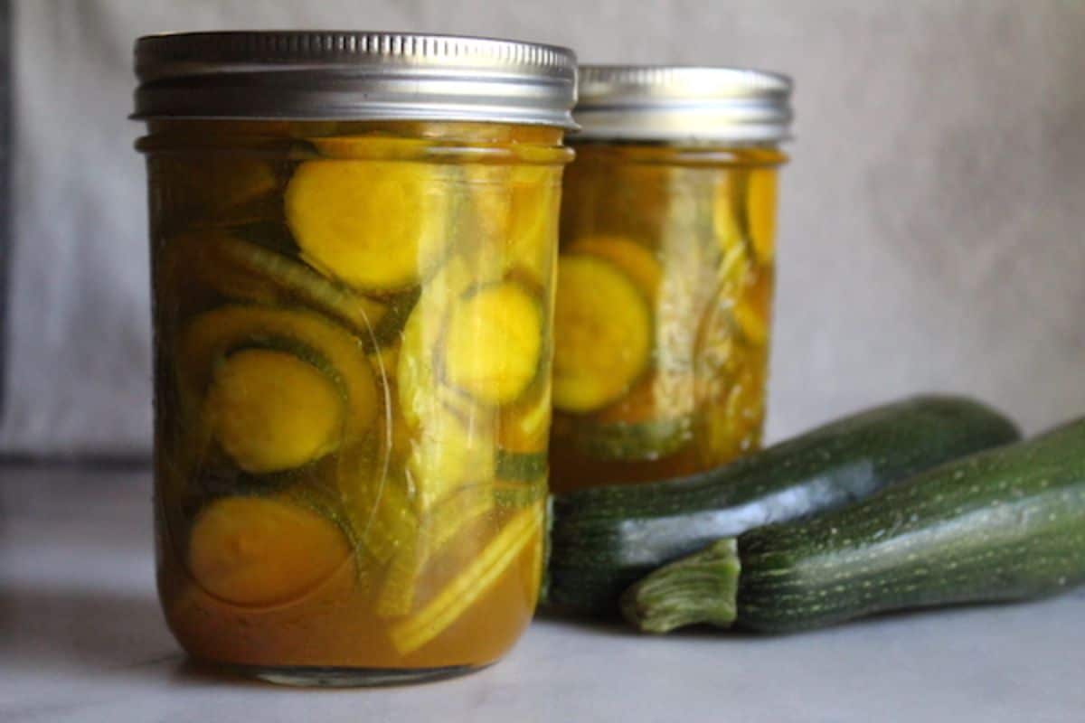 Bread and butter zucchini pickles in two glass jars.