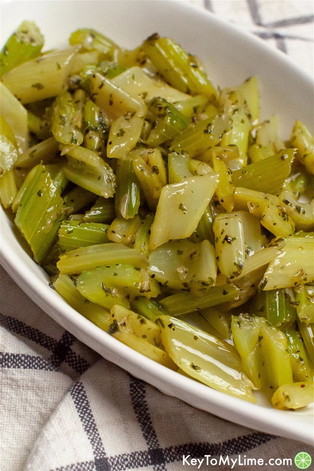 Crunchy braised celery in a white bowl.