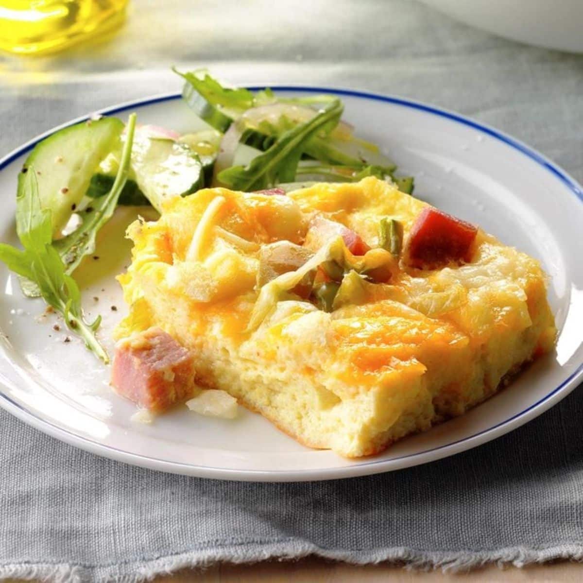 Juicy mustard ham strata with salad on a plate.