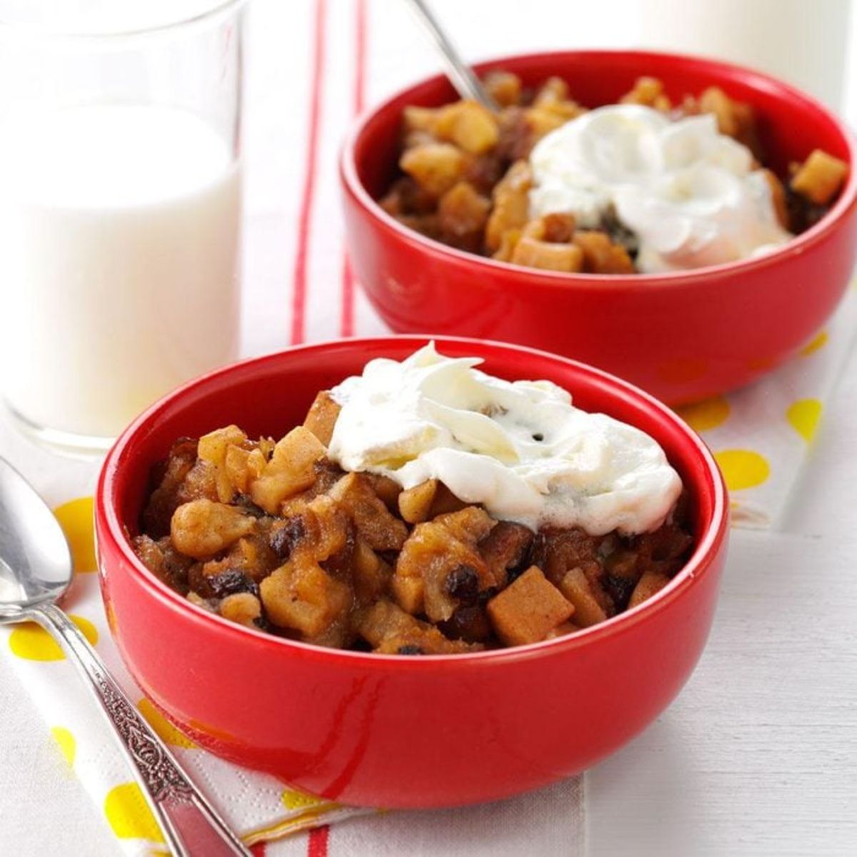 Flavorful cinnamon apple brown betties in two red bowls.